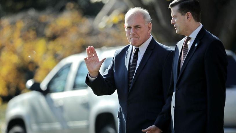 White House Chief of Staff John Kelly (L) waves to journalists as he and Staff Secretary Rob Porter leave the White House with President Donald Trump November 29, 2017 in Washington, DC. Kelly and Porter accompanied Trump to St. Charles, Missouri, for a speech and rally.