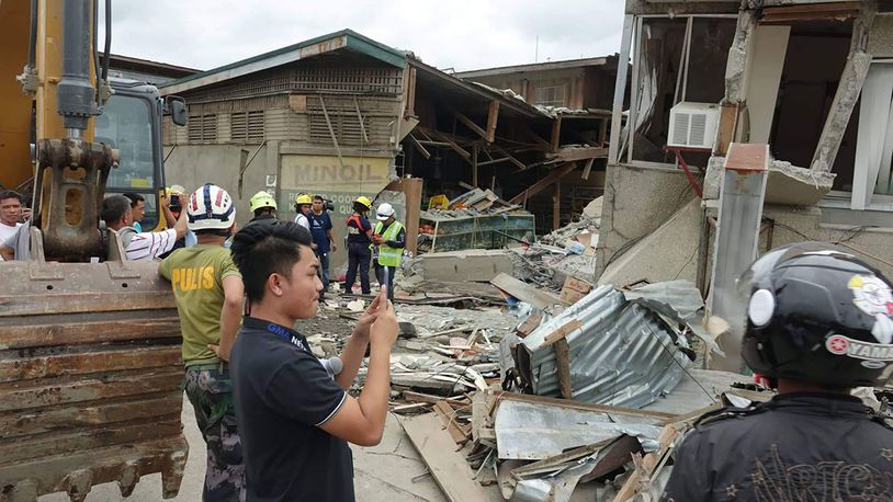 Residents and rescuers check damaged structures following an earthquake that struck Padada, Davao del Sur province, southern Philippines, on Sunday, Dec. 15, 2019.