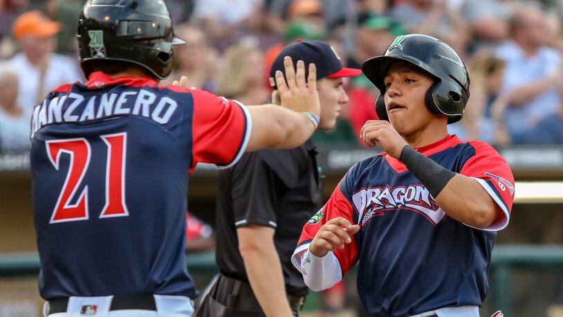 Dayton Dragons outfielder Brian Rey celebrates with Pabel Manzanero after both scored a run against the Bowling Green Hot Rods on Wednesday night at Fifth Third Field. The Dragons won 4-2. CONTRIBUTED PHOTO BY MICHAEL COOPER