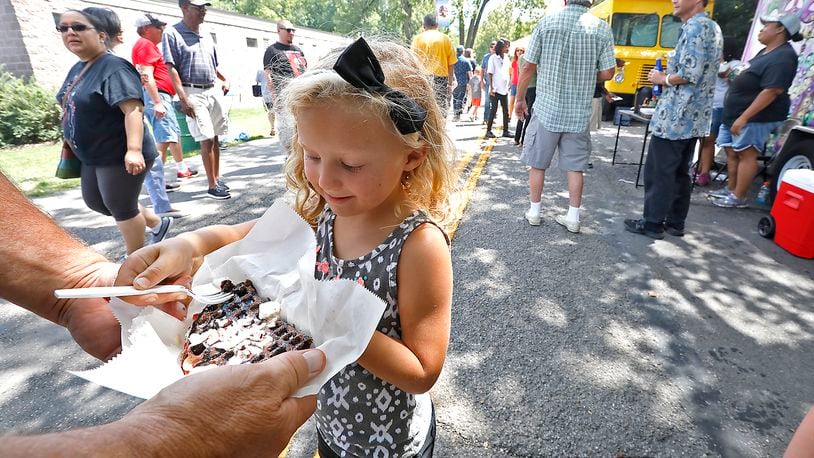Kalin Glass, 5, tries a chocolate waffle at the Springfield Rotary Food Truck Competition Saturday in Veteran's Park. Bill Lackey/Staff