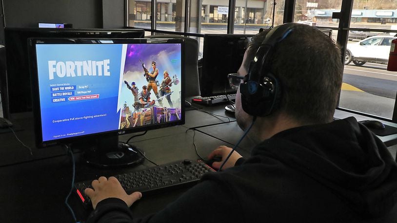 A customer gets ready to play Fortnite on a PC at Pixel Playground’s new location in The Shops at Upper Valley Pike Monday. BILL LACKEY/STAFF