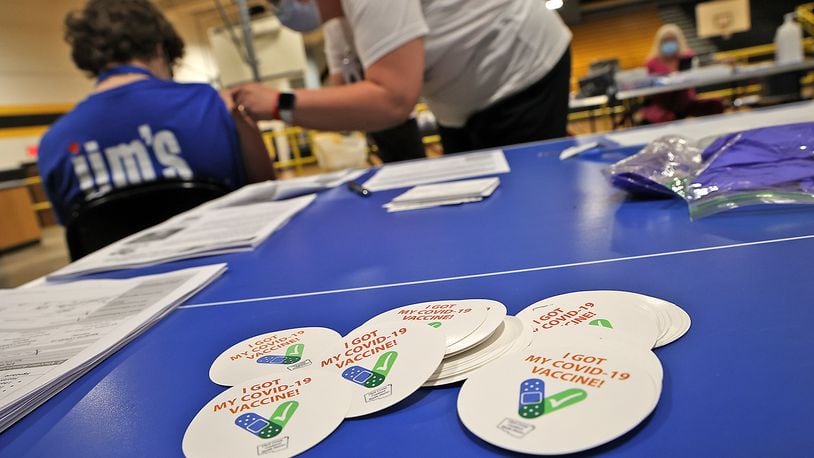 A pile of "I Got My COVID-19 Vaccine!" stickers waits for students and adults to get their vaccine shot on Monday at a vaccine clinic at Shawnee High School. Clark County's health commissioner said he credits the county's 'leveling out' of COVID-19 cases on vaccinations. BILL LACKEY/STAFF