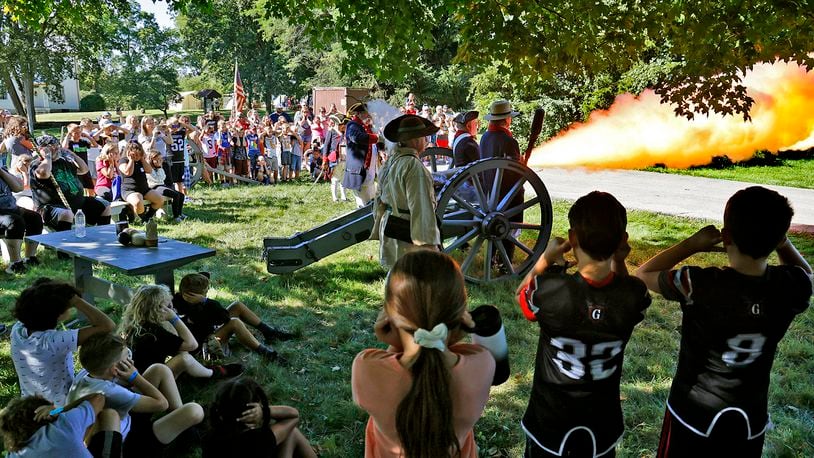 Students plug their ears as members of the First Mad River Light Artillery fire their canon Friday, Sept. 1, 2023 during the Fair at New Boston's Education Day. BILL LACKEY/STAFF