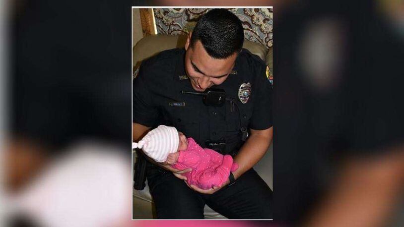 Palm Beach Gardens officer Joseph Sanchez with baby girl he helped deliver.