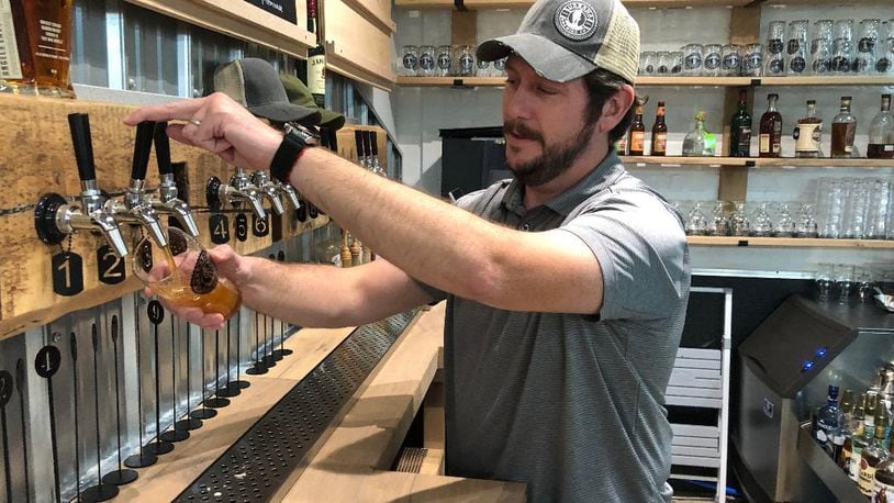 Matt Foster, general manager of the recently opened Urbana Brewing Co., pours a handcrafted beer from one of six taps. The business also offers hard seltzers, soft drinks and several food items.