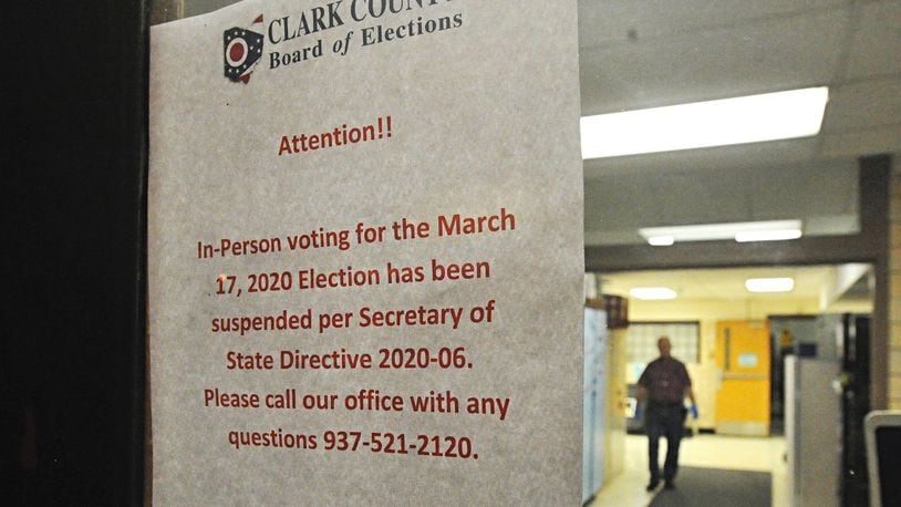 A sign on the door of the election poll at Enon Elementary tells voters the election has been postponed Tuesday morning. MARSHALL GORBY/STAFF