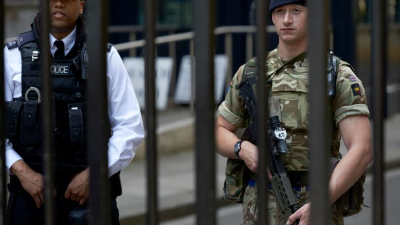 A British army soldier (R) and a police officer (L) secure an entrance to Downing Street in central London.