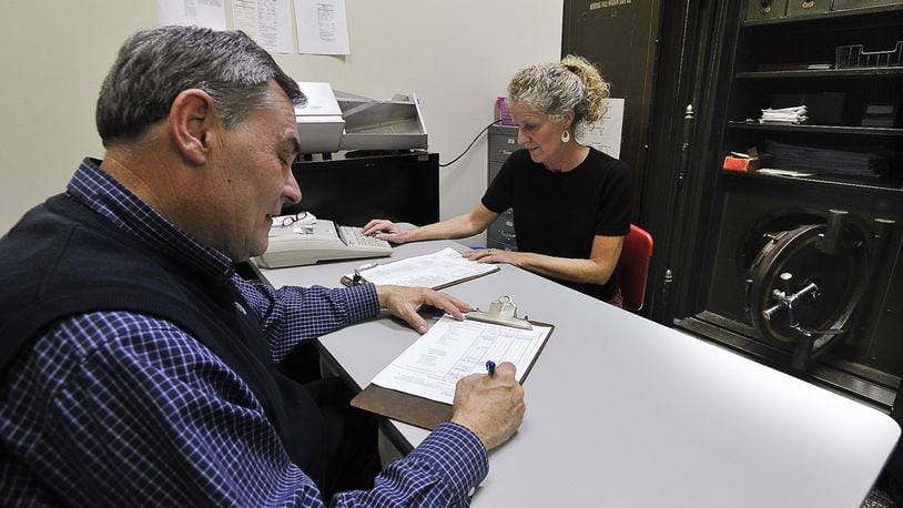 Clark County Treasurer Stephen Metzger, and treasurer employee Denise Garrett sit in a large safe as they work on a daily budget at the Treasurer’s office Monday. Staff photo by Bill Lackey