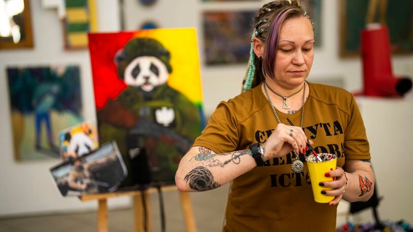 Ukrainian Anastasiya Sereda paints a canvas in an art class for women bereaved by war, in Kyiv, Ukraine, Sunday, April 28, 2024. (AP Photo/Francisco Seco)
