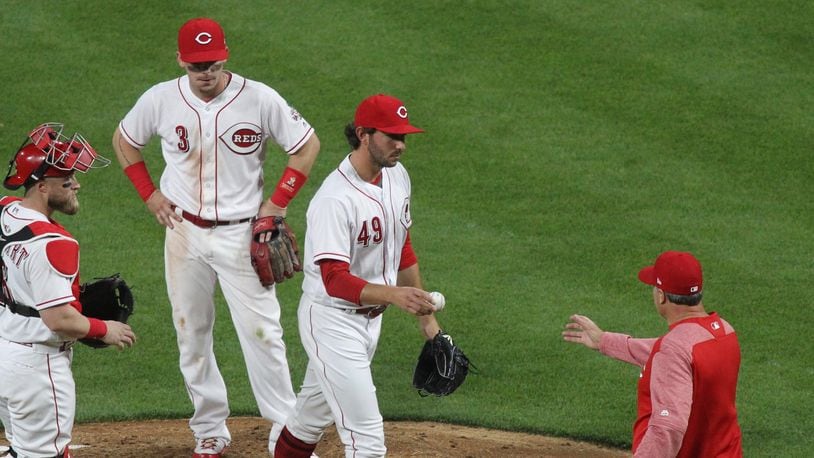 Reds reliever Zack Weiss hands the ball to manager Bryan Price after being removed from the game in the seventh inning on Thursday, April 12, 2018, against the Cardinals at Great American Ball Park in Cincinnati.