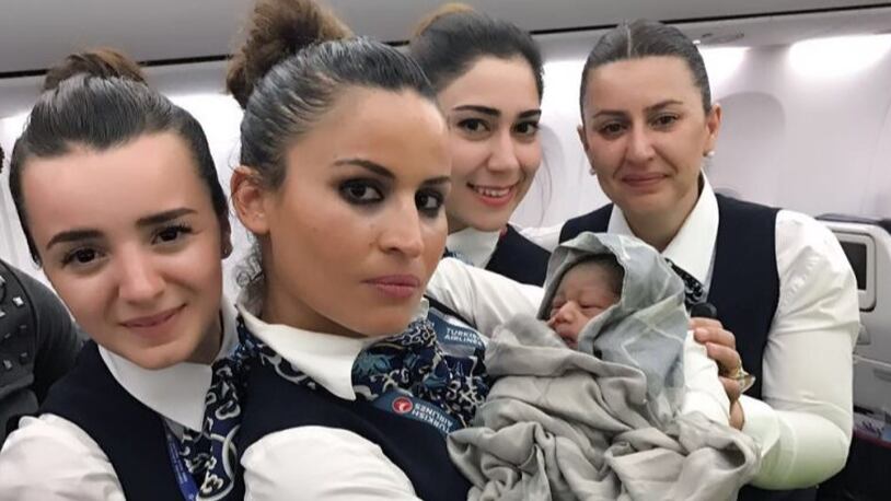 A cabin crew of Turkish Airlines pose for a photo with a baby born in a plane during a flight from Conakry to Ouagadougou to Istanbul on April 7, 2017 in the air. (Photo by Turkish Airlines / Handout/Anadolu Agency/Getty Images)
