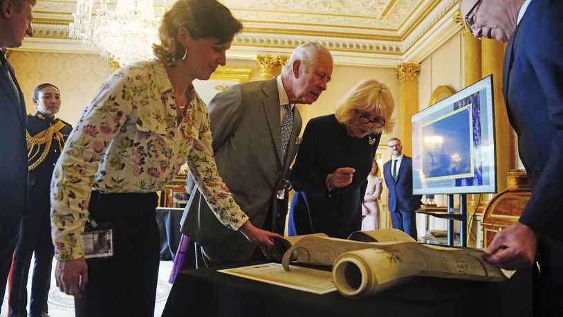 Britain's King Charles III and Queen Camilla are shown Coronation Rolls of previous monarchs after being presented with their own Coronation Roll, an official record of their Coronation, at Buckingham Palace, central London, Wednesday May 1, 2024. King Charles III gaped at the 70-foot-long (21.4-meter) hand-lettered scroll as it was presented to him earlier this week at Buckingham Palace, thanking the artisans who produced the document that serves as the official record of his coronation almost a year ago. (Victoria Jones/PA via AP)