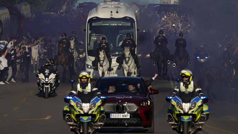 Police officers escort the bus carrying the Real Madrid players outside the Santiago Bernabeu stadium, ahead of the Champions League quarterfinal first leg soccer match between Real Madrid and Manchester City in Madrid, Spain, Tuesday, April 9, 2024. This week's Champions League soccer games will go ahead as scheduled despite an Islamic State terror threat. A media outlet linked to the terror group has issued multiple posts calling for attacks at the stadiums hosting quarterfinal matches in Paris, Madrid and London. (AP Photo/Andrea Comas)