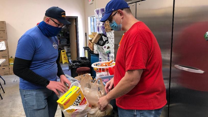 Volunteers Chris Brown, right, and son Jacob Brown organize food to go to needy community members Saturday morning at the Good Samaritan Outreach Center. Photo by Brett Turner