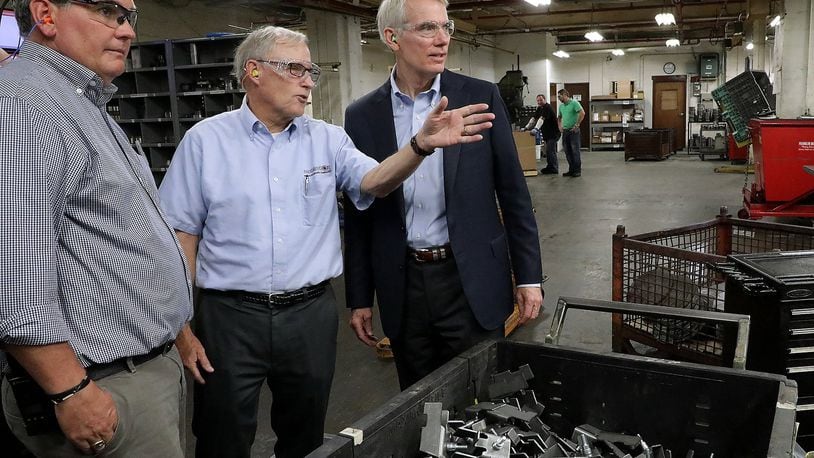 Andrew Brougher and Dan McGregor, from the Morgal Machine Tool Company, talk about the manufacturing plant’s production with Senator Rob Portman during a tour of the facility Tuesday. BILL LACKEY/STAFF