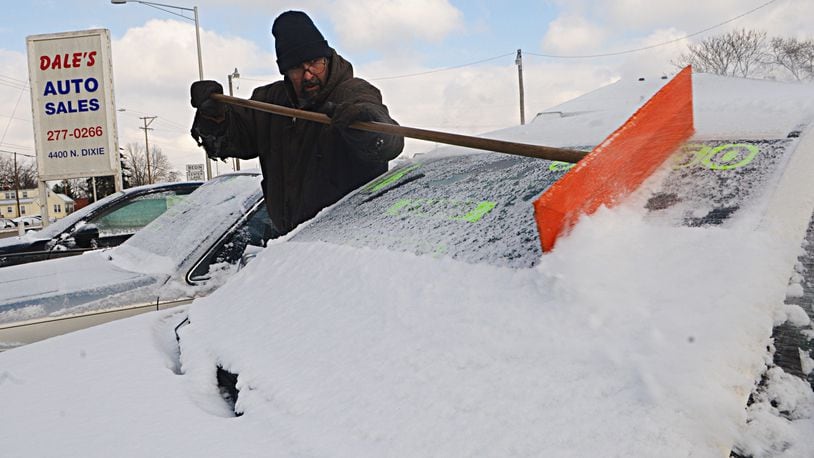 Bitter cold will dip thermometers this weekend before an Alberta clipper brings in snow late Monday. Here, James Mylo removes snow Thursday morning, Feb. 9, 2017, from the cars at Dale’s Auto Sales located at 4400 North Dixie. MARSHALL GORBY / STAFF