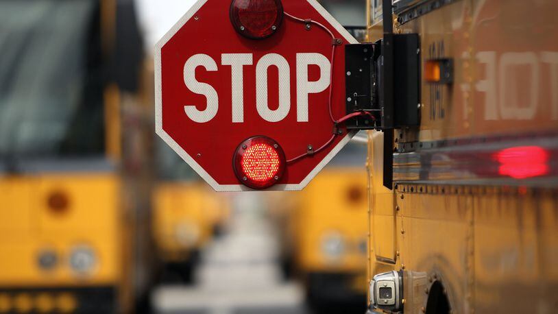 When a school bus has its lights flashing and its stop signs extended, drivers must stop — unless they are on the opposite side of the road from the bus, and there is a five-foot barrier or unpaved median. (Damon Higgins/The Palm Beach Post)