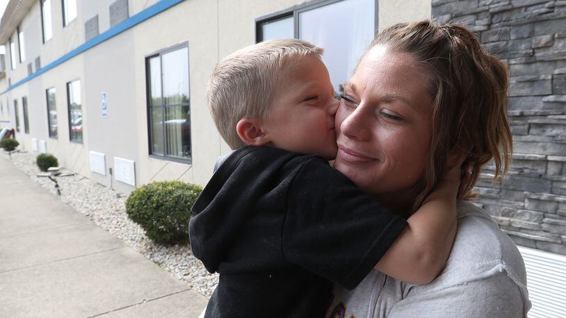 Julie Johns gets a kiss from her son, Maddox, outside the Motel 6 where they are currently living. According to Julie, they were homeless until the Interfaith Hospitality Network helped them and set them up in the motel. BILL LACKEY/STAFF