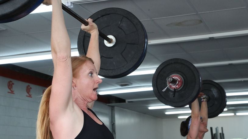 Julie Sasala, left, and the rest of the noon class at Champion City CrossFit were glad the gym on Upper Valley Pike was allowed to reopen Tuesday. BILL LACKEY/STAFF