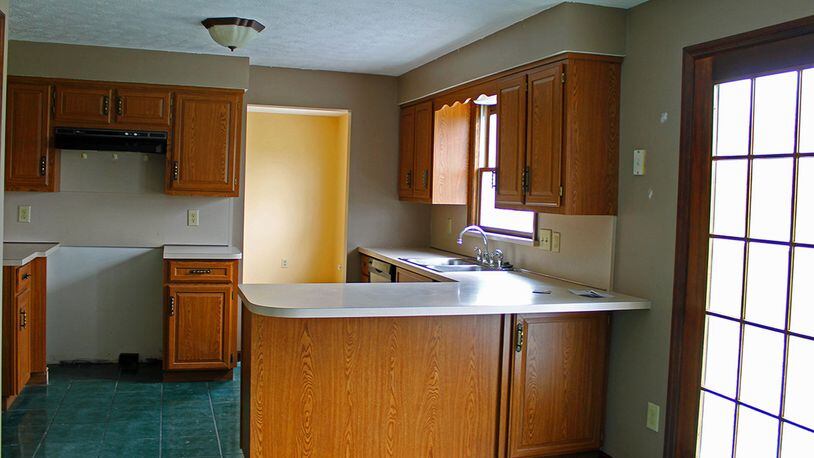 Features of the kitchen include a breakfast bar and plenty of wood cabinetry.