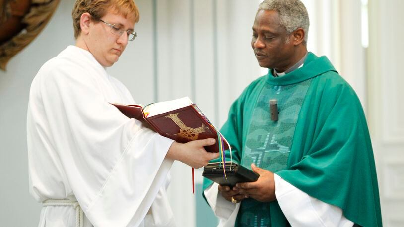 Cardinal Peter Turkson of Ghana (right) presided over a Mass at the University of Dayton's Immaculate Conception Chapel in 2012. At left attending to the service is Will Marsh a recent UD graduate.
