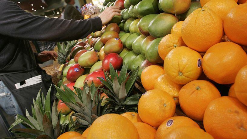 A grocer arranges mangoes in the produce section at Whole Foods January 13, 2005 in New York City. (Photo by Stephen Chernin/Getty Images)