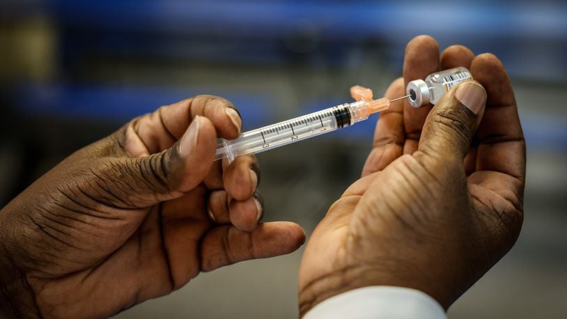 Anthony Watson R.N. fills a syringe with COVID-19 vaccine at a clinic held at Horizon Science Academy Friday March 11, 2022. JIM NOELKER/STAFF
