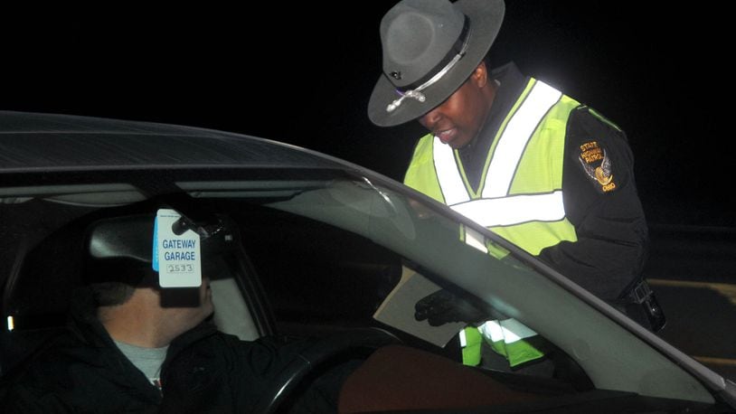 A Ohio State Highway Patrol trooper hands out an information sheet to a driver during an OVI sobriety checkpoint. David A. Moodie/Contributor