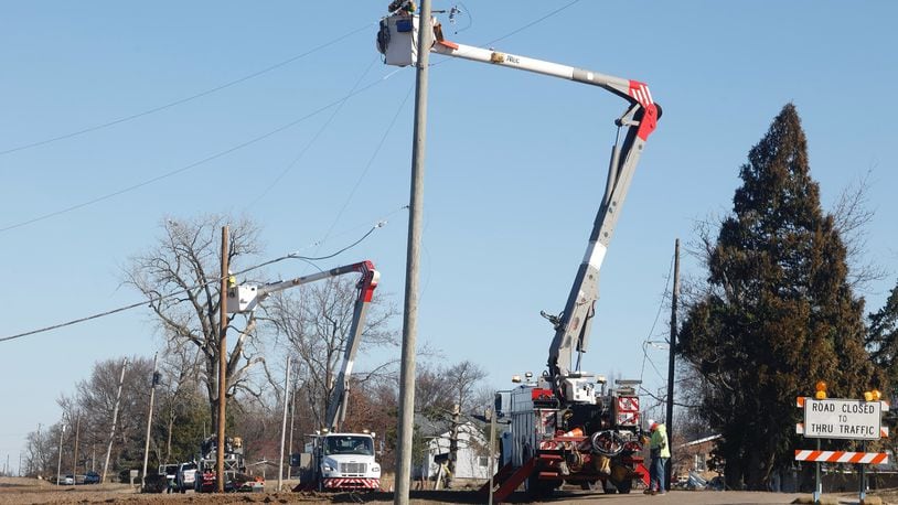 Ohio Edison crews replace utility poles along Fletcher Pike Thursday. BILL LACKEY/STAFF