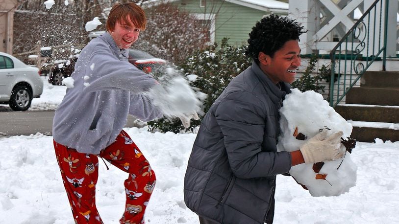 Hayden Frederick hits Antonio Crowe in the back with a snowball as Antonio packs together a giant snowball of his own Monday, Jan. 23, 2023 while the two friends have a snowball fight along East Cecil Avenue in Springfield. The duo were enjoying their day off school due to the weather. BILL LACKEY/STAFF