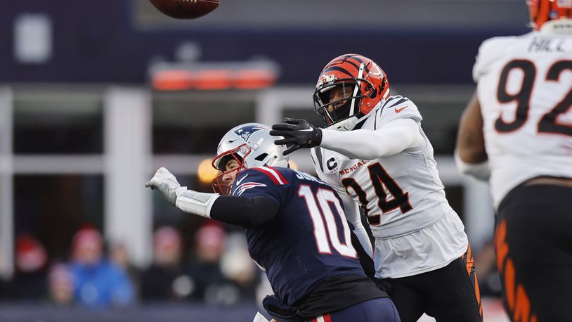 New England Patriots quarterback Mac Jones (10) loses control of the ball under pressure from Cincinnati Bengals safety Vonn Bell (24) during the second half of an NFL football game, Saturday, Dec. 24, 2022, in Foxborough, Mass. (AP Photo/Michael Dwyer)