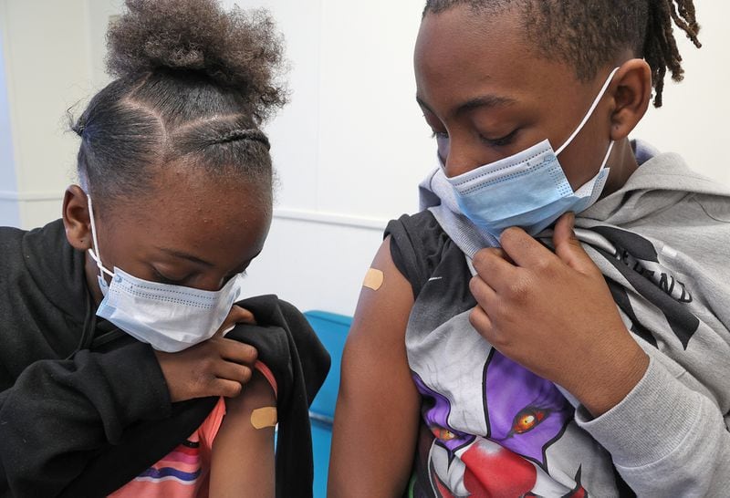Ta'Niah Walker, 9, and her brother, Terrance, 11, check out where they got their COVID vaccine injections Friday, Feb.  25, 2022 at the Clark County Combined Health District.  BILL LACKEY / STAFF