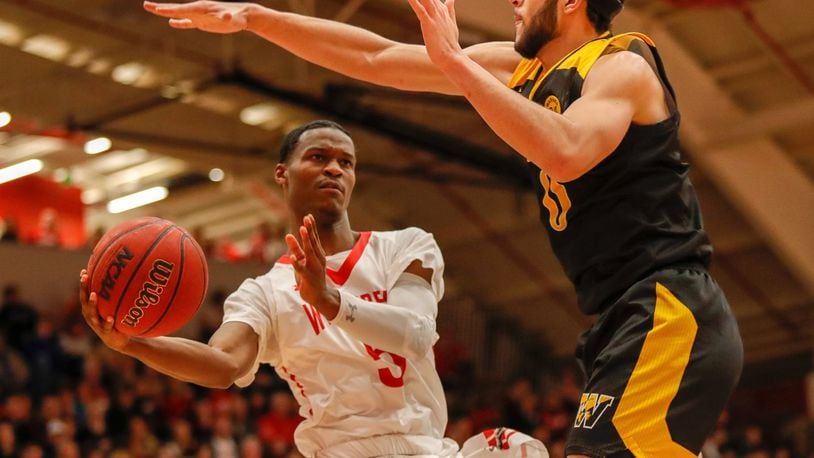Wittenberg University’s Rashaad Ali-Shakir passes around Wooster’s Dontae Williams during their game on Saturday night at Pam Evans Smith Arena in Springfield. The Tigers won 88-81 to claim their 13th North Coast Athletic Conference title. CONTRIBUTED PHOTO BY MICHAEL COOPER