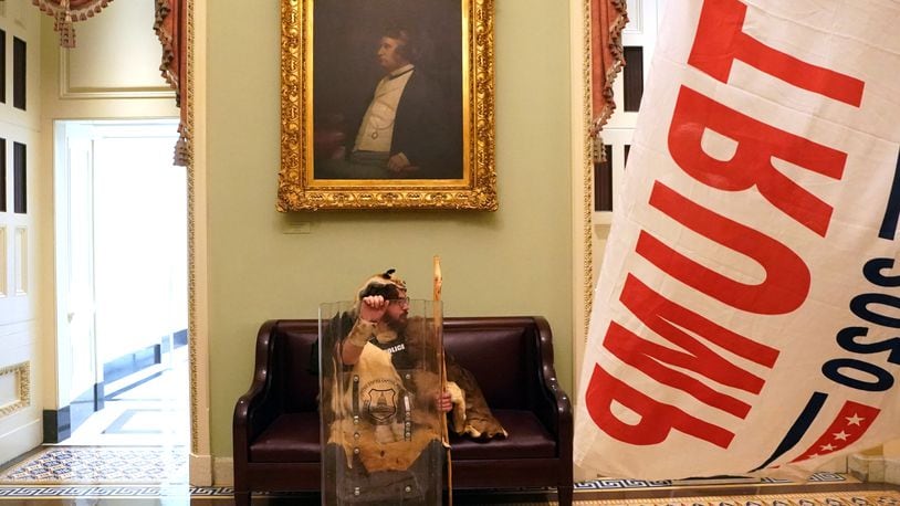 A protester with a tactical shield sits in a hallway of the Capitol  in Washington on Wednesday, Jan. 6, 2020, after supporters of President Donald Trump breached security and entered the building. A mob of people loyal to President Trump stormed the Capitol on Wednesday, halting Congress’s counting of the electoral votes to confirm President-elect Joe Biden’s victory as the police evacuated lawmakers from the building in a scene of violence, chaos and disruption that shook the core of American democracy. (Erin Schaff/The New York Times)