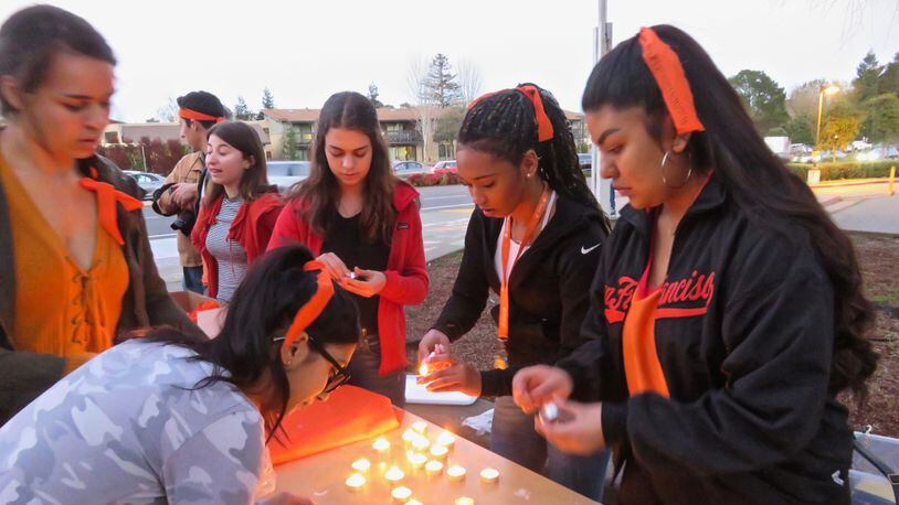 Students wear orange in support of victims of gun violence at a vigil at Tam High School in Mill Valley, California on February 15, 2018.