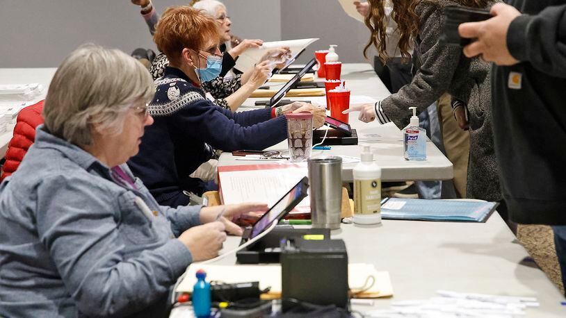Poll workers check voters in at the First Christian Church on Middle Urbana Road Tuesday, March 19, 2024. BILL LACKEY/STAFF