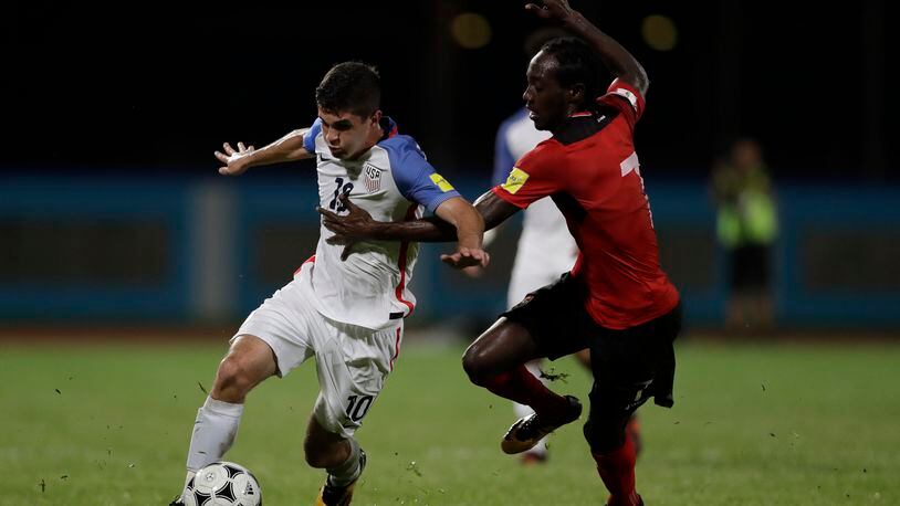 United States’ Christian Pulisic, left, fight for the ball with Trinidad and Tobago’s Nathan Lewis during a 2018 World Cup qualifying soccer match in Couva, Trinidad, Tuesday, Oct. 10, 2017. (AP Photo/Rebecca Blackwell)
