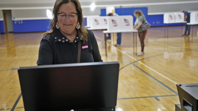Vikki Hayden slides her ballot in the voting machine Tuesday, Nov. 7, 2023 at Roosevelt Middle School. BILL LACKEY/STAFF