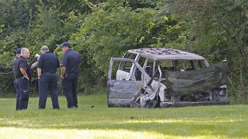 Members of the Springfield Police and the Fire Marshall’s office investigate a burned out SUV in Sherman Park Thursday, June 29, 2017 after a dead body was found inside the vehicle. Bill Lackey/Staff