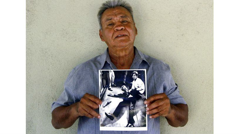 This photo provided by STORYCORPS shows Juan Romero holding a Los Angeles Times photograph that shows Romero aiding Sen. Robert F. Kennedy at the Ambassador hotel in Los Angeles, moments after Kennedy was shot just after midnight June 5, 1968. Romero, who was a 17-year-old busboy when Kennedy was assassinated, held the mortally wounded Kennedy as he lay on the ground, struggling to keep the senator's bleeding head from hitting the floor. Romero died Monday, Oct. 1, 2018, at age 68.