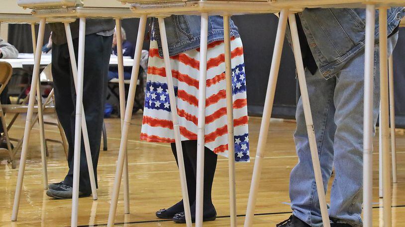 A woman was showing her patriotic spirit with the stars and stripes on her dress as she voted in a voting booth at Tecumseh High School. BILL LACKEY/STAFF