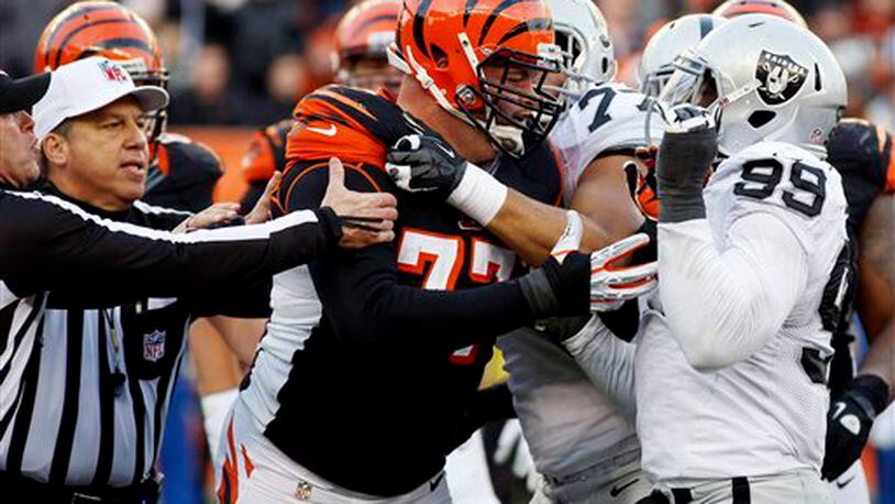 Cincinnati Bengals tackle Andrew Whitworth (77) fights with Oakland Raiders defensive end Lamarr Houston (99) in the second half of an NFL football game, Sunday, Nov. 25, 2012, in Cincinnati. Both players were ejected from the game. The Bengals won 34-10. (AP Photo/David Kohl)