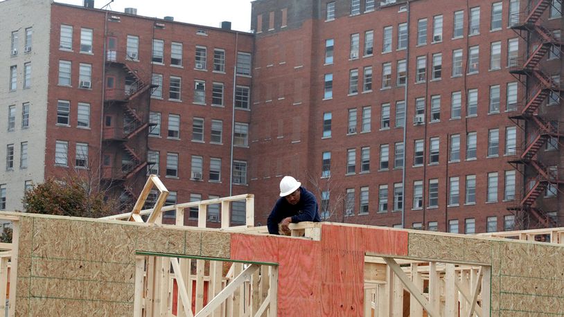Hull Plaza rises up behind a construction worker framing the new Center Street Townhomes in downtown Springfield. The townhomes are just one of several projects that are changing the face of downtown Springfield. BILL LACKEY/STAFF