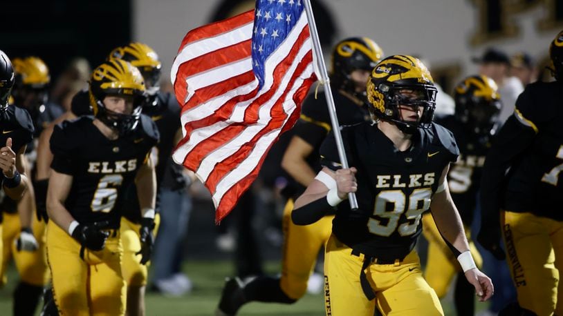Centerville's Matthew Jones carries the flag onto the field before a Division I, Region 2 playoff game against Springfield on Friday, Nov. 3, 2023, at Centerville. David Jablonski/Staff