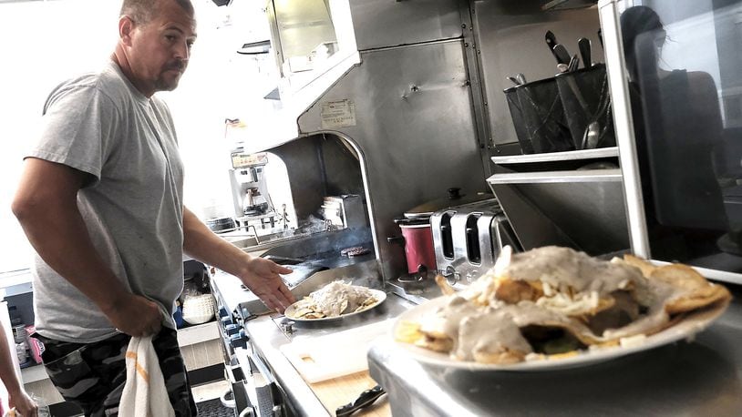 Jeff Wade, the owner and cook at Mobile Dogs Cafe, hard at work at the grill. Bill Lackey/Staff