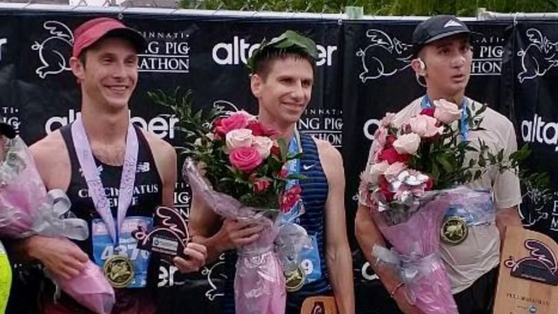 Jason Salyer, center, poses for a photo after winning the Flying Pig Marathon on Sunday, May 7, 2023, in Cincinnati. Salyer won his second straight Flying Pig Marathon on Sunday in Cincinnati. Photo by Jim Salyer