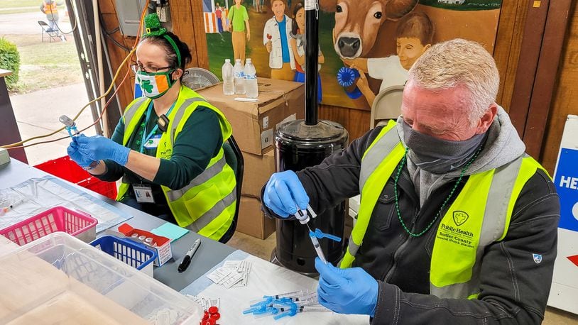 Kristin Harbeson, left, and Scott Schmits prepare vaccines for distribution. The Butler County General Health District held a drive through COVID-19 vaccination clinic Wednesday, March 17, 2021 at Butler County Fairgrounds in Hamilton. Nearly 75 workers and volunteers administered 1500 vaccines during the event.  NICK GRAHAM / STAFF