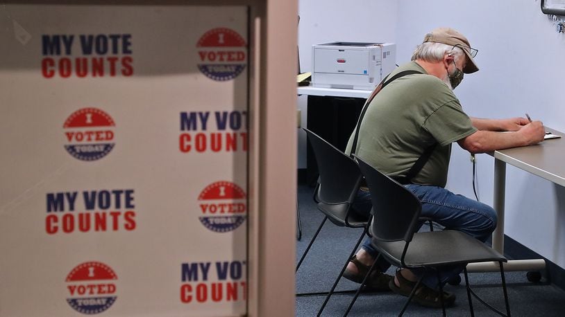 A voter casts his vote at the Champaign County Board of Election during the April election. BILL LACKEY/STAFF