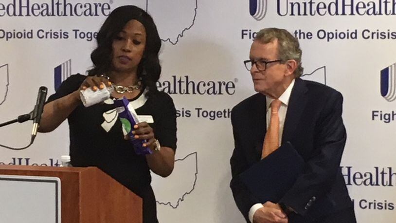 Dr. Corinn Taylor, left, demonstrates an opioid disposal kit as Ohio Attorney General Mike DeWine watches during an event Thursday, June 7 at Kettering Medical Center in Kettering. WILL GARBE / STAFF