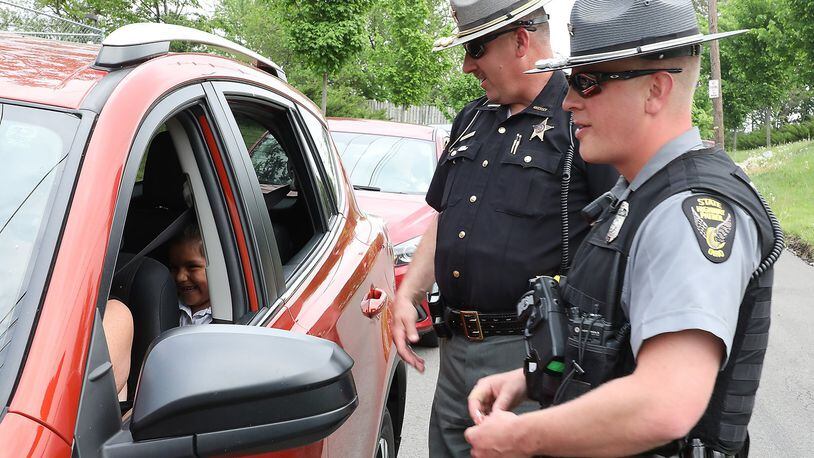 Clark County Sheriff’s Deputy Mark Lane and Sgt. Merrill Thompson of the Ohio State Highway Patrol check drivers to make sure they are wearing their seatbelts as they leaving Catholic Central High School. The safety check kicked off their Click It Or Ticket campaign that runs through June 4. Bill Lackey/Staff